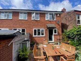 Rear of a brick semi-detached house before its loft conversion