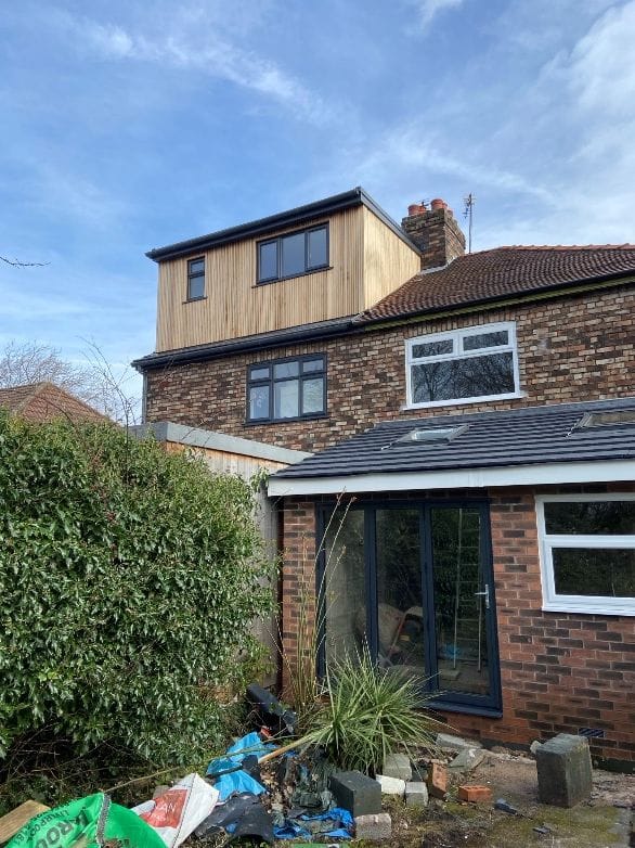 Completed timber-clad dormer on a brick house